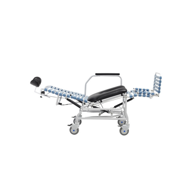  The image shows a white-framed commode chair with black padding on the seat and headrest. The chair features a tilt-in-space mechanism, illustrated with transparent overlays showing different reclined positions. It has armrests, footrests, and four caster wheels for mobility.